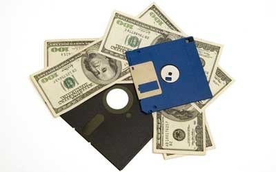 multiple hundred dollar bills underneath 5 ¼" floppy disk and 3 ½" computer disk